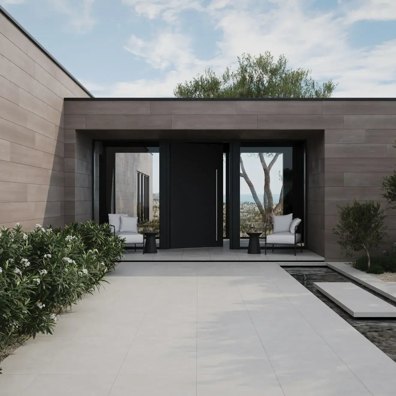 Modern entrance showcasing sleek design with porcelain tile, lush greenery, and inviting seating area.