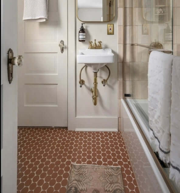 Bathroom featuring Makoto Umi Terracotta 2" round matte porcelain mosaic tile on the floor with elegant fixtures.