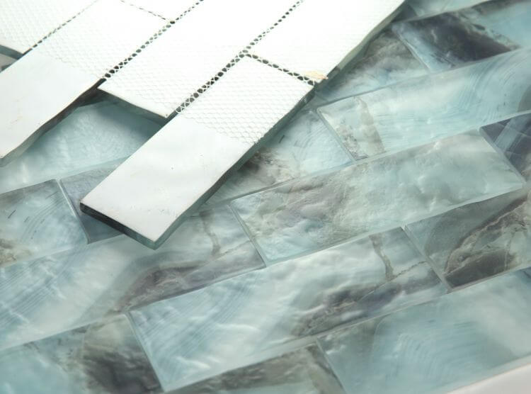 Art Onyx Ocean 11.75 x 11.75 glass tile in a linear brick pattern with grout samples for installation.