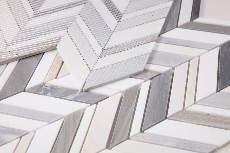 Chevron Shadow Blue marble mosaic in Chevron pattern, showcasing blue, grey, and white tones with a polished finish.