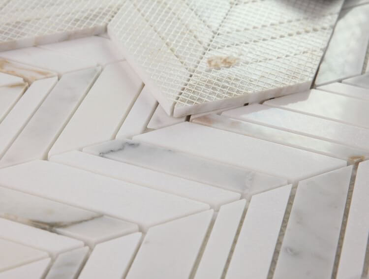 Chevron Shadow Calacatta marble mosaic tile in white and gold, showcasing polished finish and intricate pattern design.