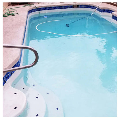 Clear swimming pool with blue tiled edges and cleaning equipment, showcasing a clean and inviting aquatic space.