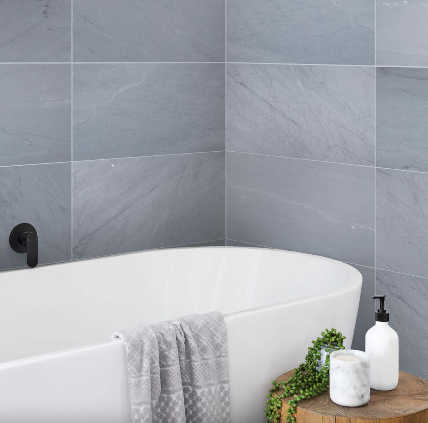 Bathroom featuring 12x24 Bardiglio Imperiale Marble Tile with bluish-grey tones, modern freestanding tub, and stylish décor.
