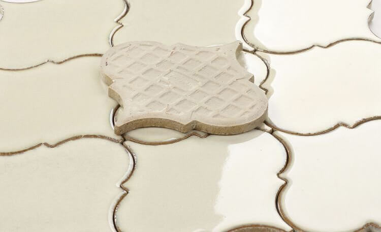 Calabash Ivory 6x6 handmade porcelain arabesque tiles laid out, featuring high variation for pool use.