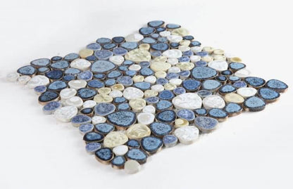 Poseidon Ocean 11.50 x 11.50 Pebble Mosaic Tile featuring blue, white, and beige porcelain pebbles arranged on a mesh sheet.