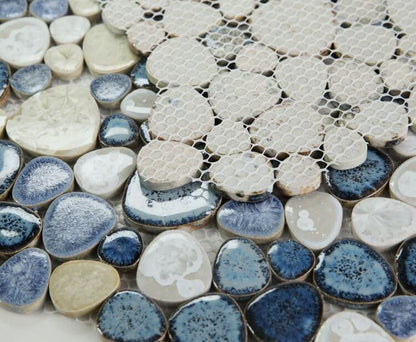 Close-up of Poseidon Ocean 11.50" x 11.50" pebble mosaic tile showcasing smooth blue, white, and beige porcelain pebbles.